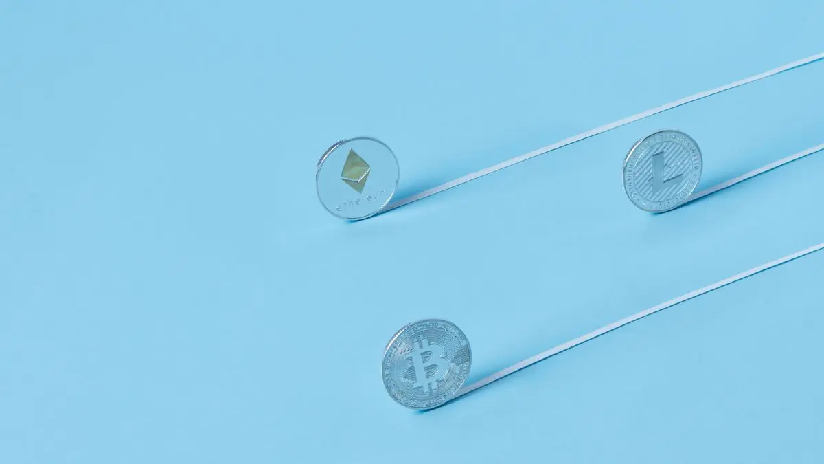 Cryptocurrency souvenir coins on a pale blue surface.