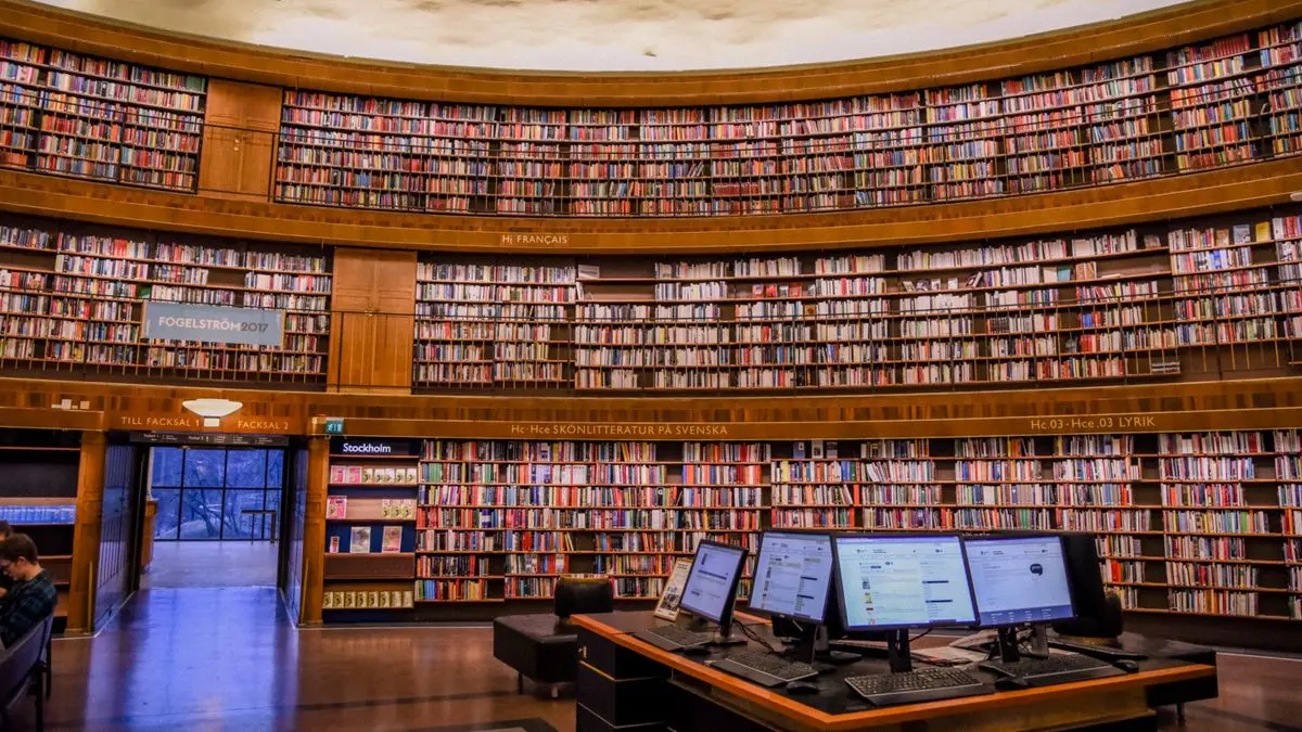 Bookshelves and computer monitors inside a library.