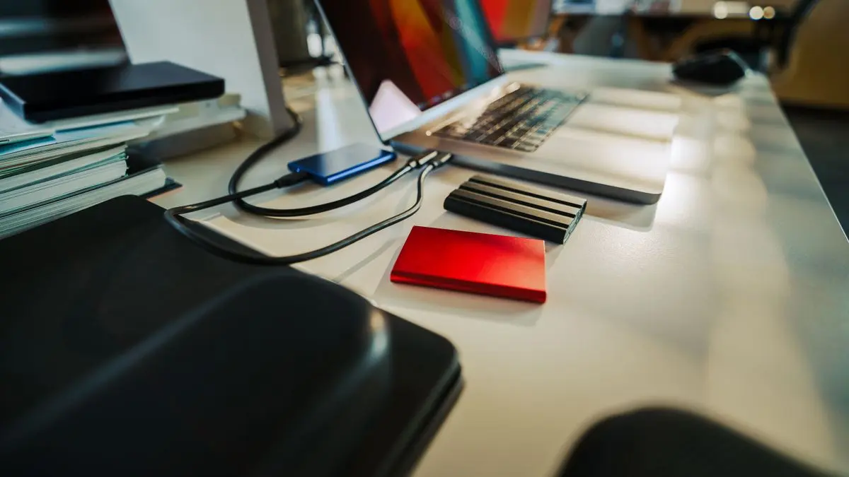 Laptop and external storage drives on a desk.